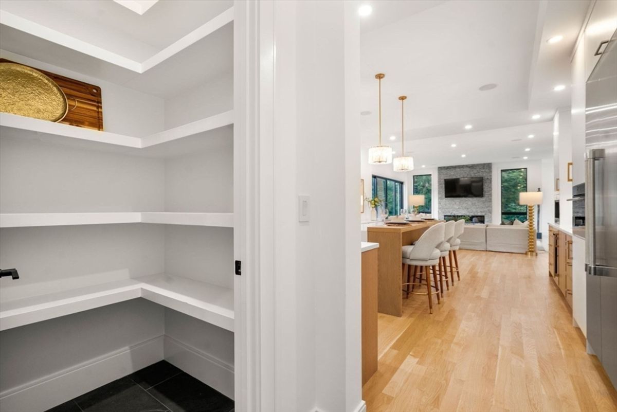 Walk-in pantry with ample shelving conveniently located near the kitchen.