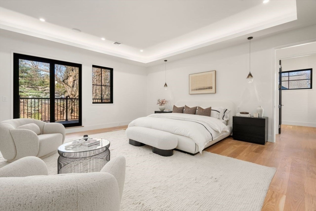 Spacious bedroom layout enhanced by sleek pendant lighting and natural wood accents.