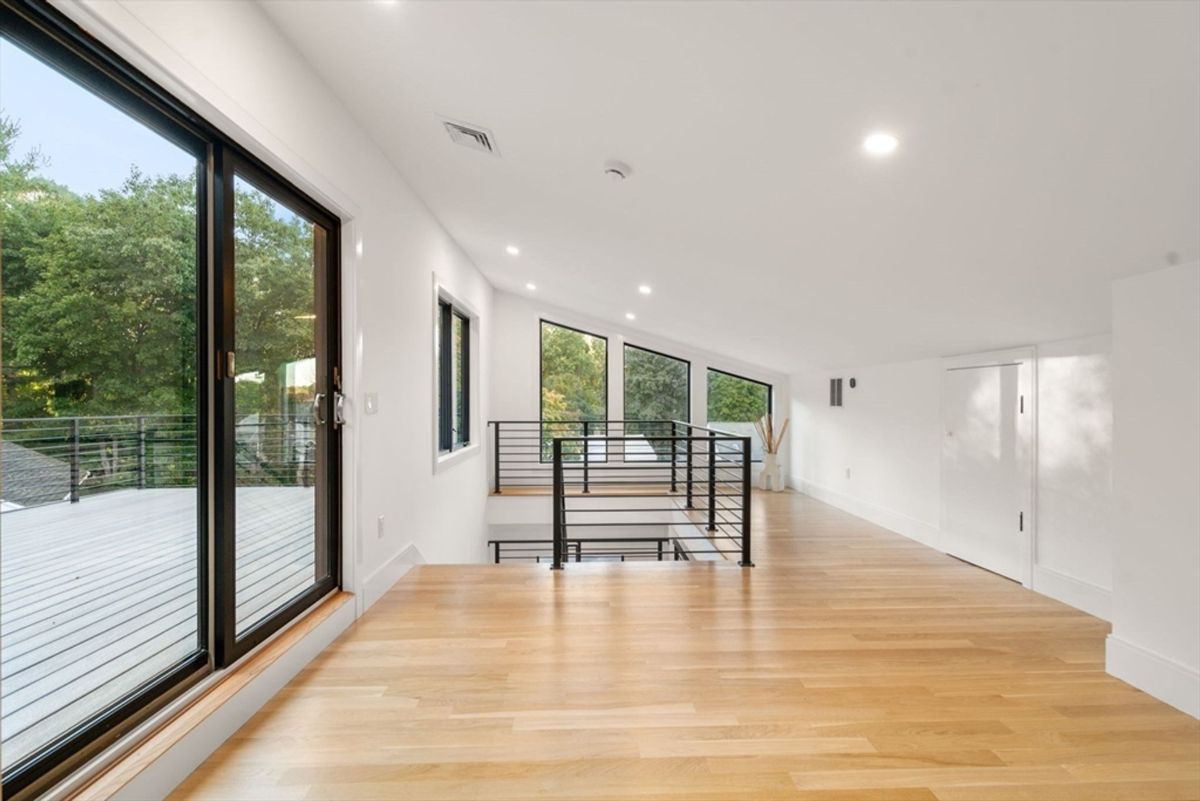 Loft-style area with large windows and access to a private deck.