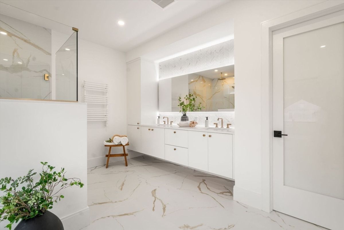 Modern bathroom with a dual-sink vanity, marble-patterned flooring, and built-in LED-lit mirrors.