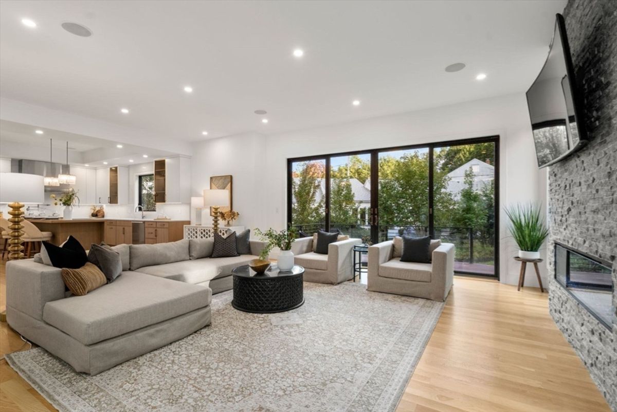 Open living area connects to a sleek kitchen, offering abundant natural light through floor-to-ceiling windows.