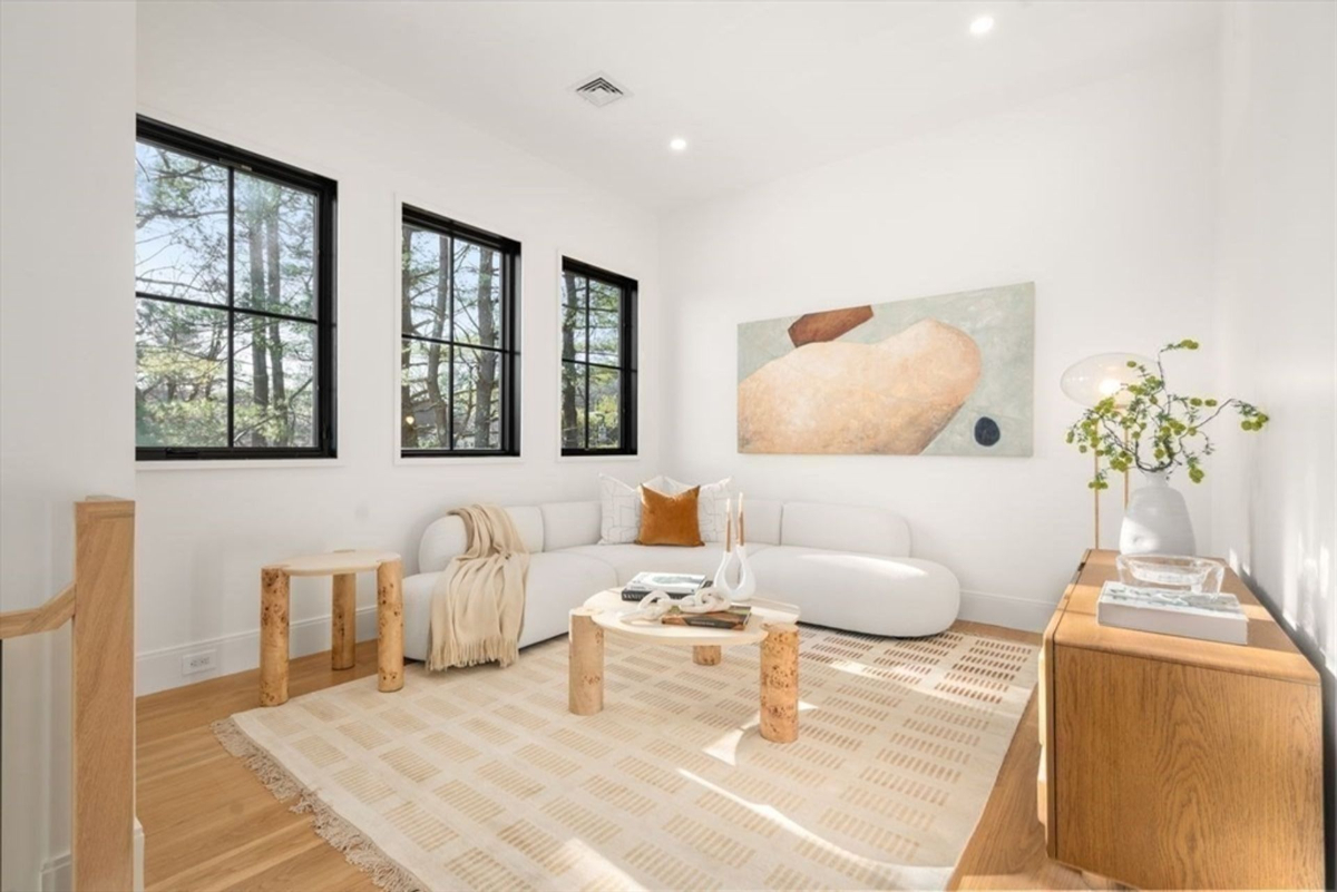 Bright sitting room bathed in natural light, showcasing large windows and soft furnishings.