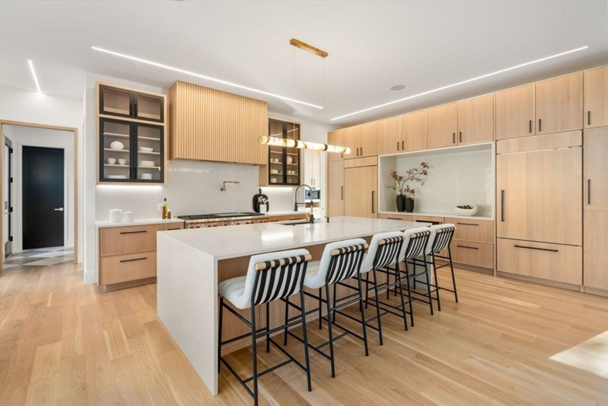 Modern kitchen featuring a large island with stylish seating and warm wood cabinetry.