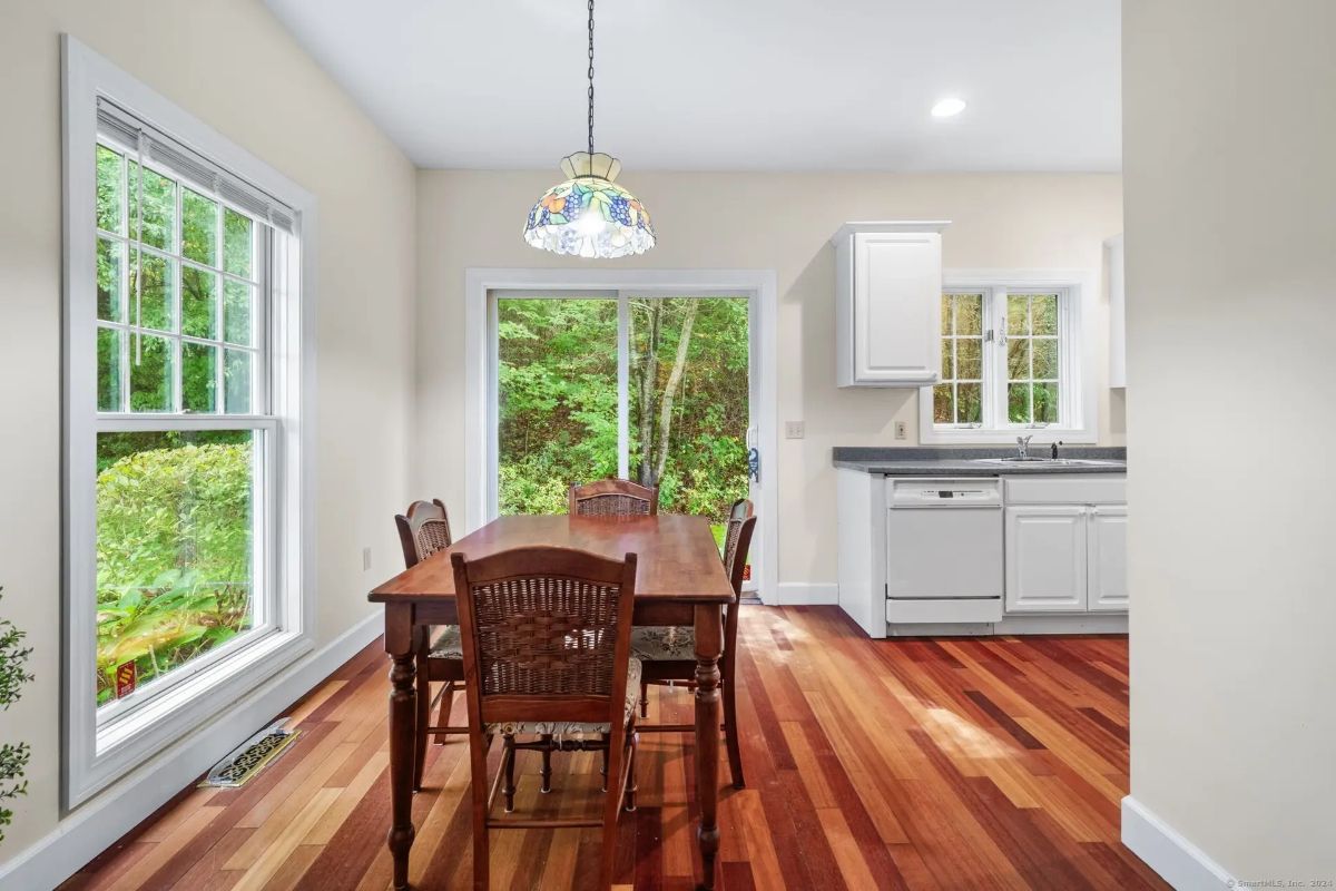 Kitchen with white cabinets, a gray countertop, and hardwood floors.