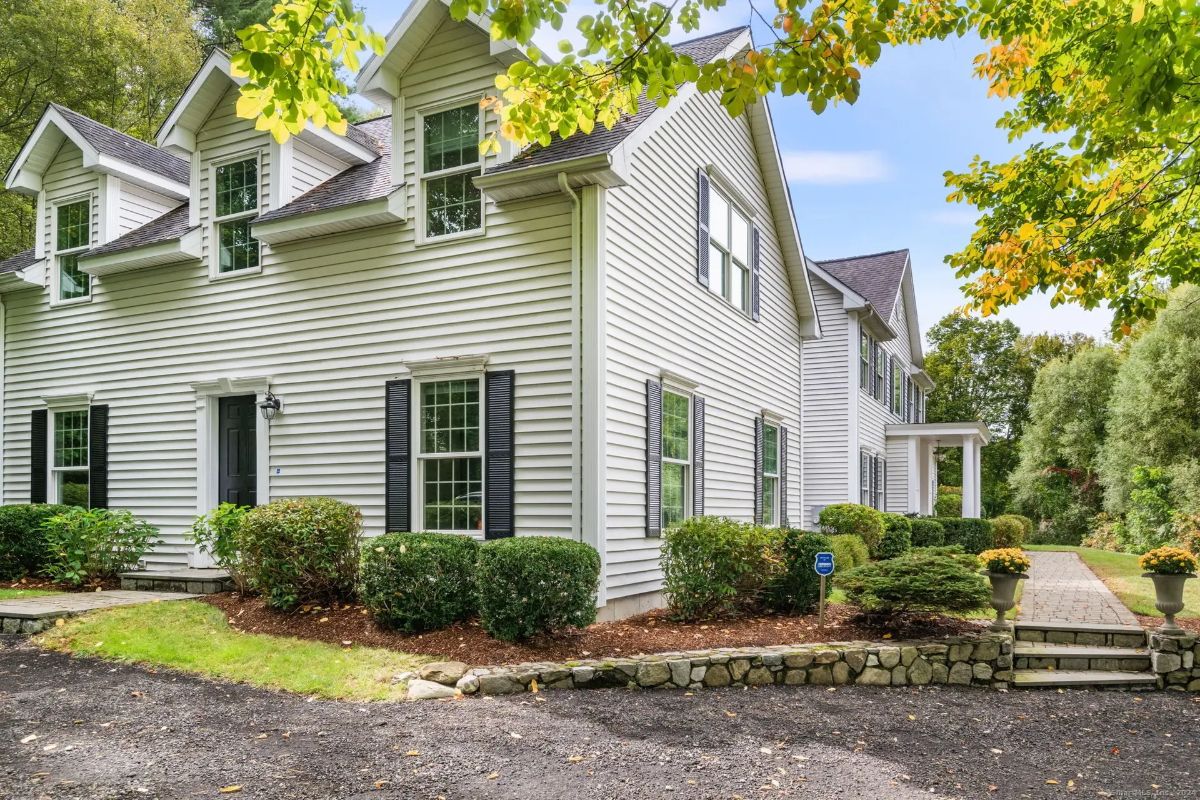 Side view of the house highlighting well-maintained landscaping and a charming walkway leading to the entrance.