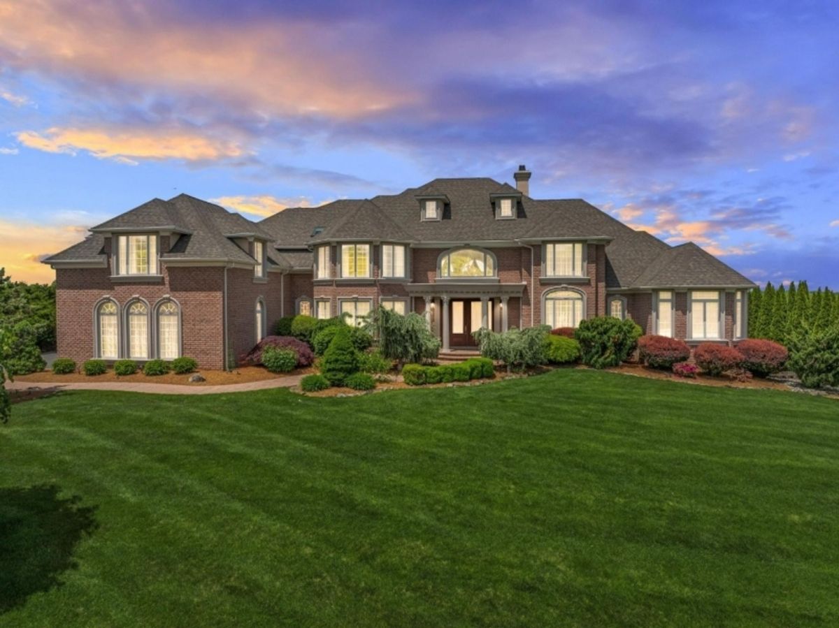 Stunning twilight view highlighting the mansion's grandeur and well-maintained front lawn.