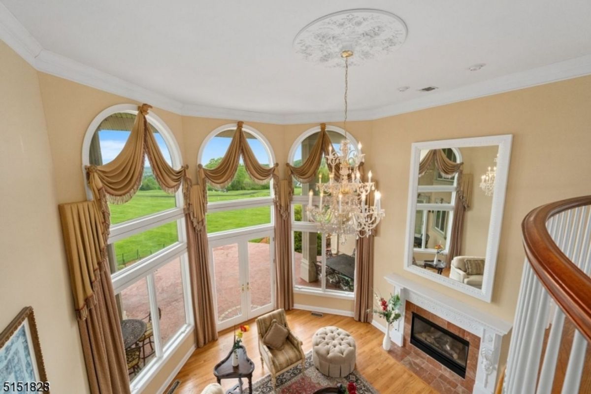 Overhead view of a luxurious living space with high windows and a central chandelier.