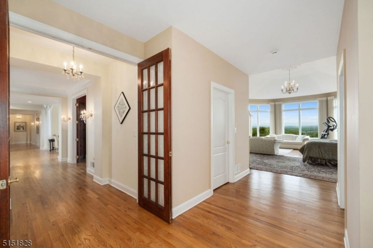 Bright hallway leading to a master suite with panoramic window views.