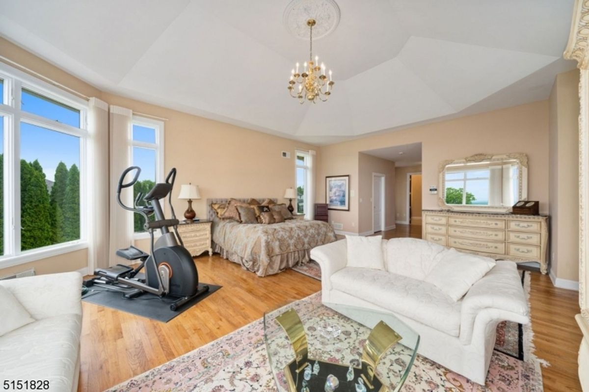 Spacious master suite combining a private lounge, fitness area, and elegant bedroom furnishings.