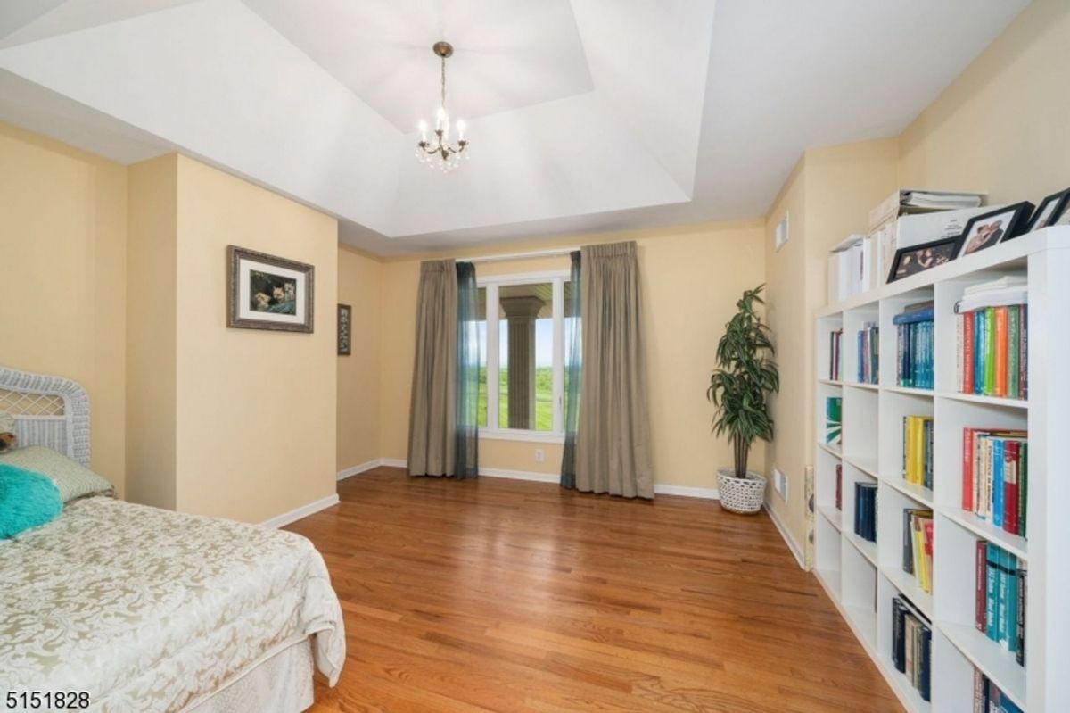 Bedroom with cozy reading nook with built-in shelves and hardwood flooring.