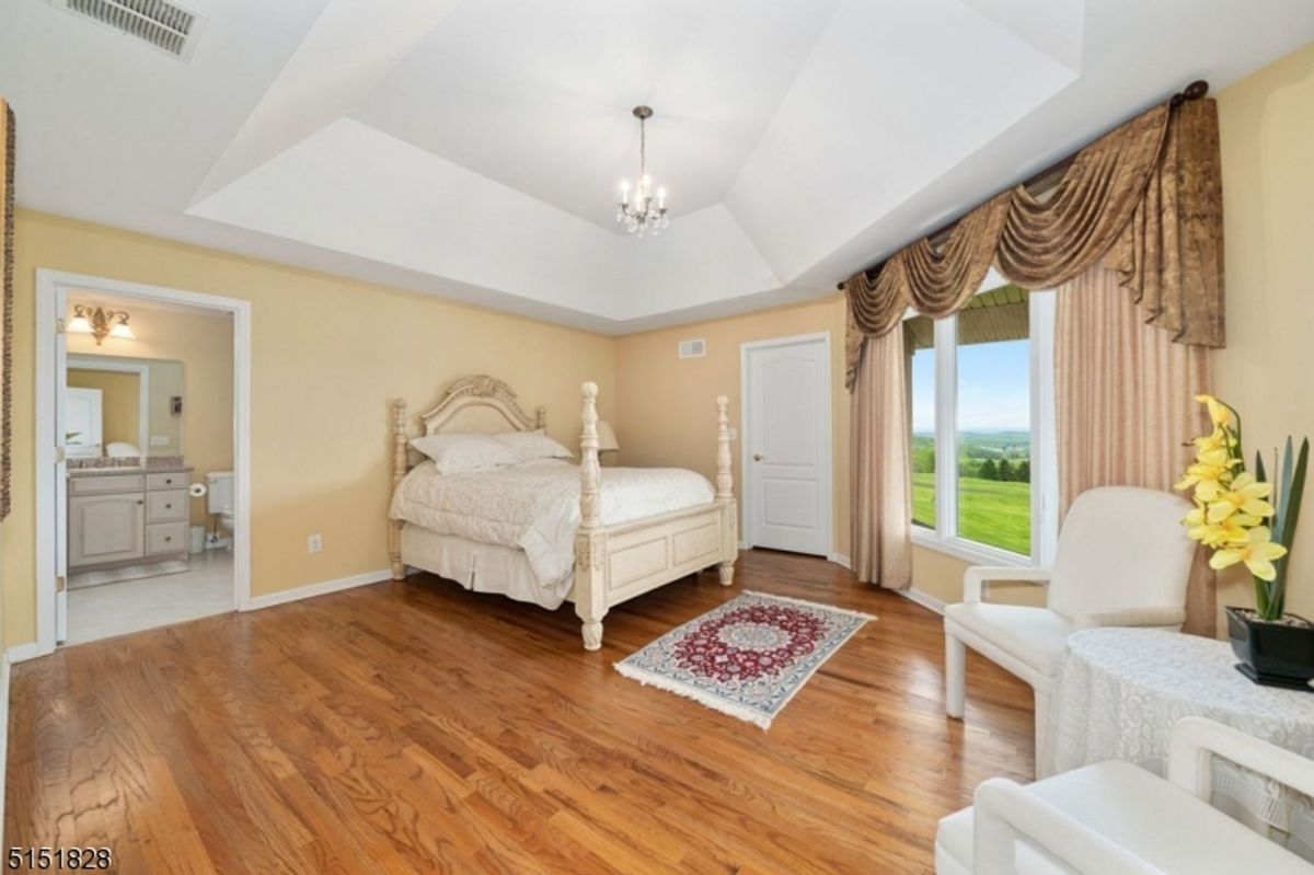 Elegant bedroom with classic decor and serene outdoor views.