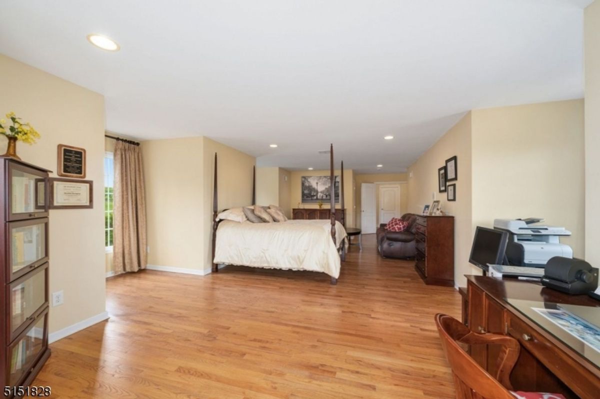 Expansive master bedroom suite featuring sitting areas and wood flooring.