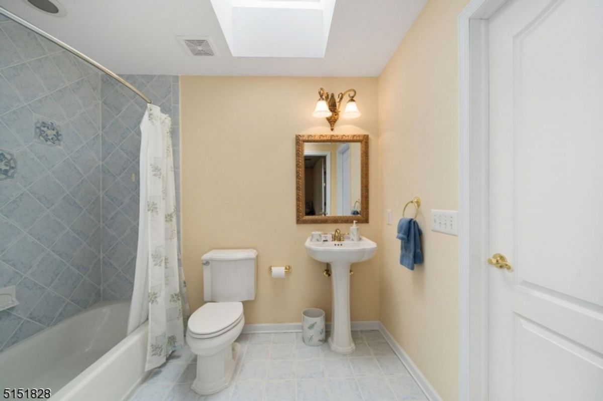 Bathroom with pedestal sink and skylight.