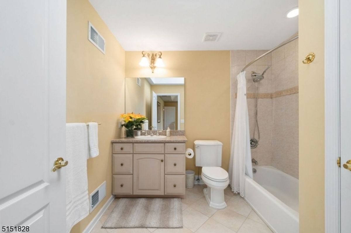 Bathroom with a granite countertop and neutral tile.