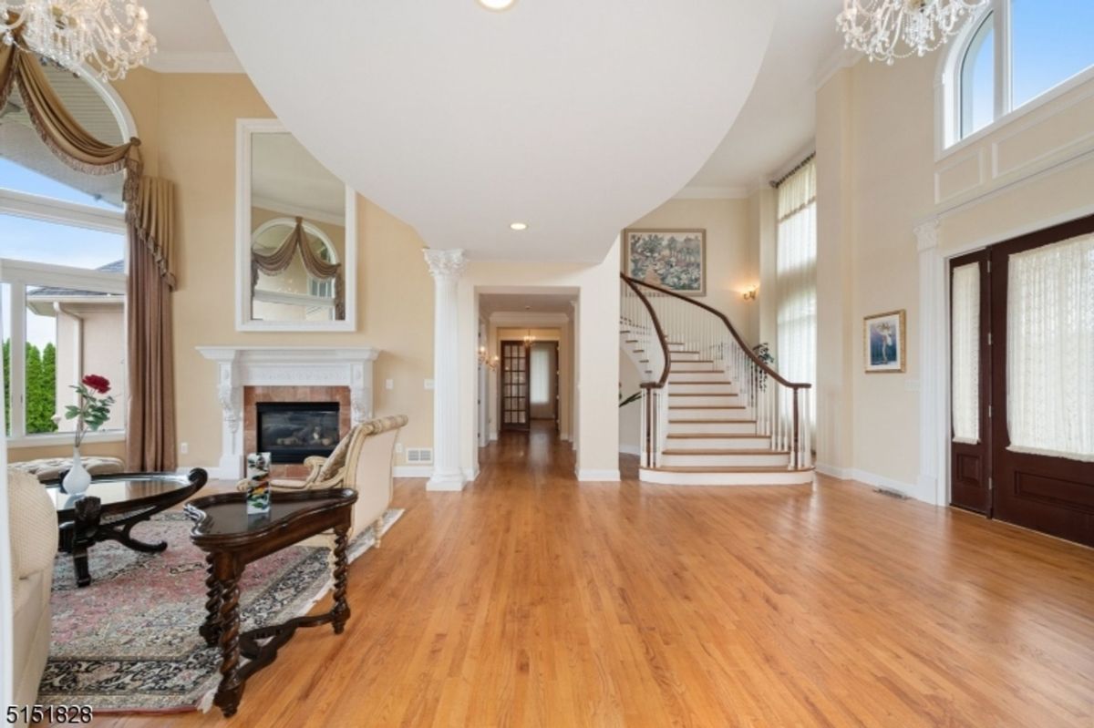 Living area with a cozy fireplace, arched windows, and elegant furnishings.