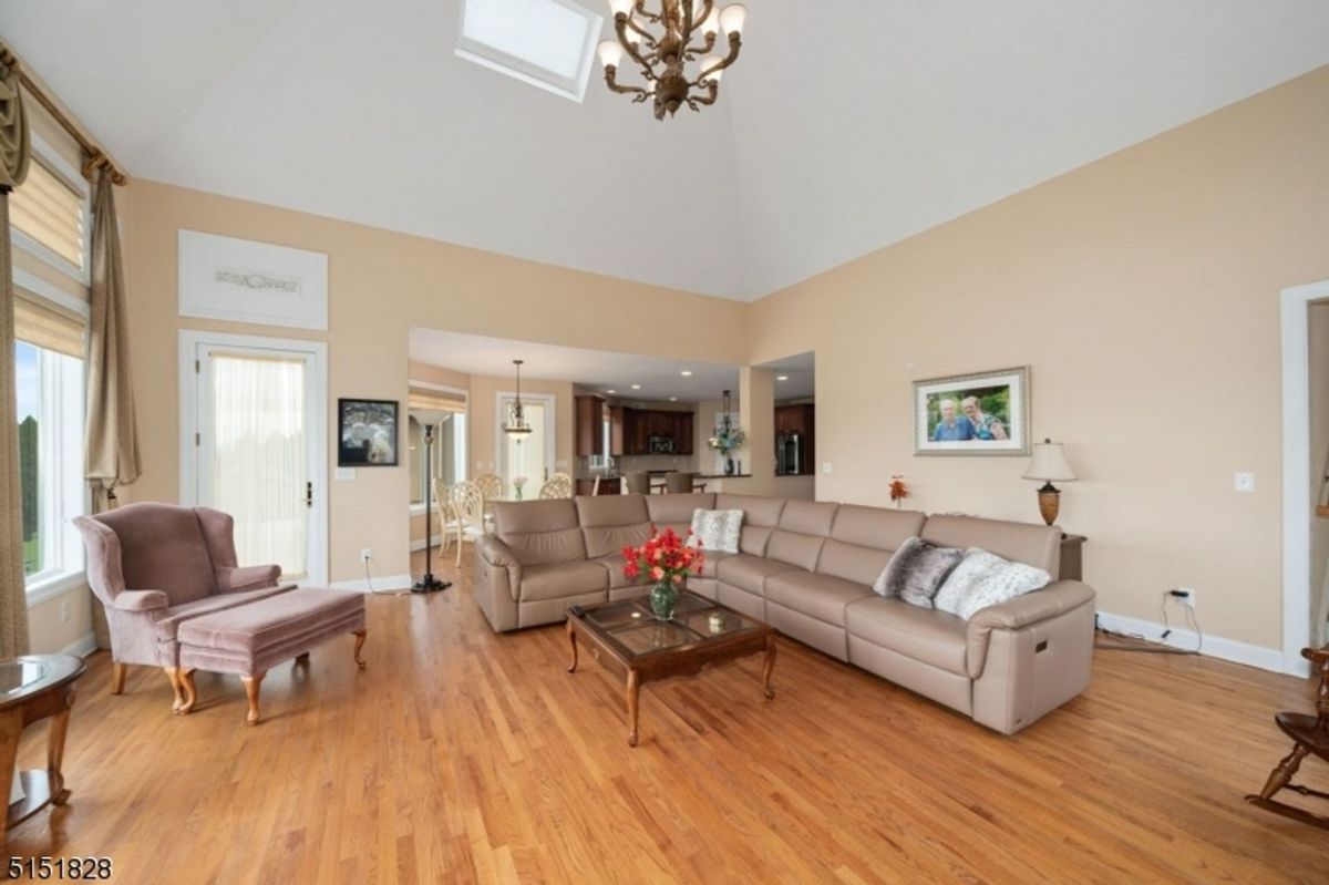 Bright family room with vaulted ceilings, ample seating, and open access to the kitchen.