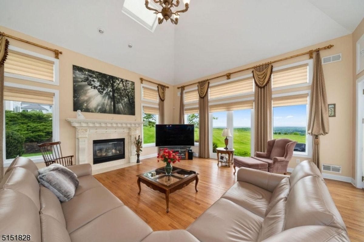 Cozy family room with large sofas, elegant drapery, and a classic fireplace mantle.