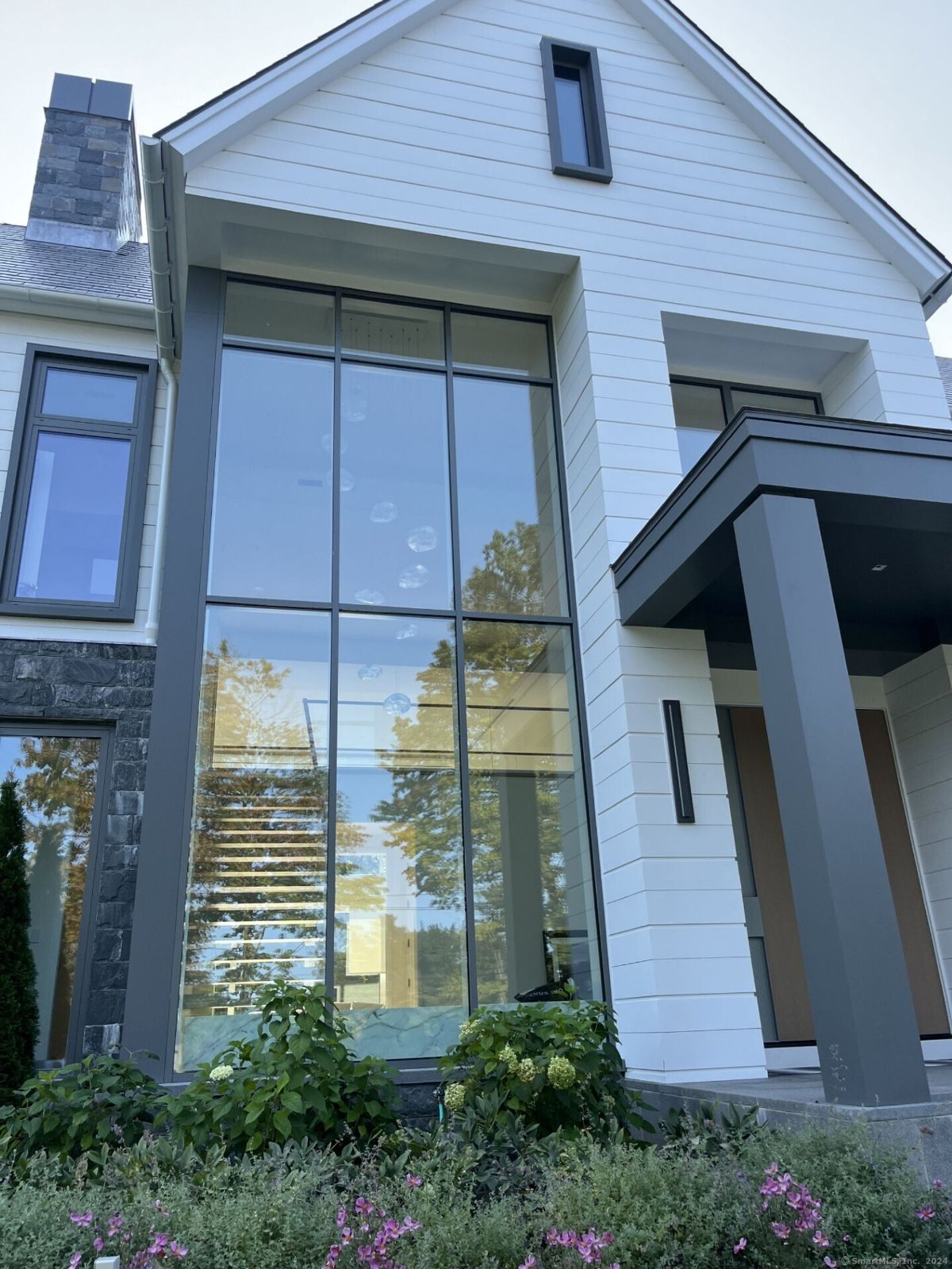 Floor-to-ceiling windows showcase the home's clean lines and flood the interior with natural light, creating an airy and modern aesthetic.