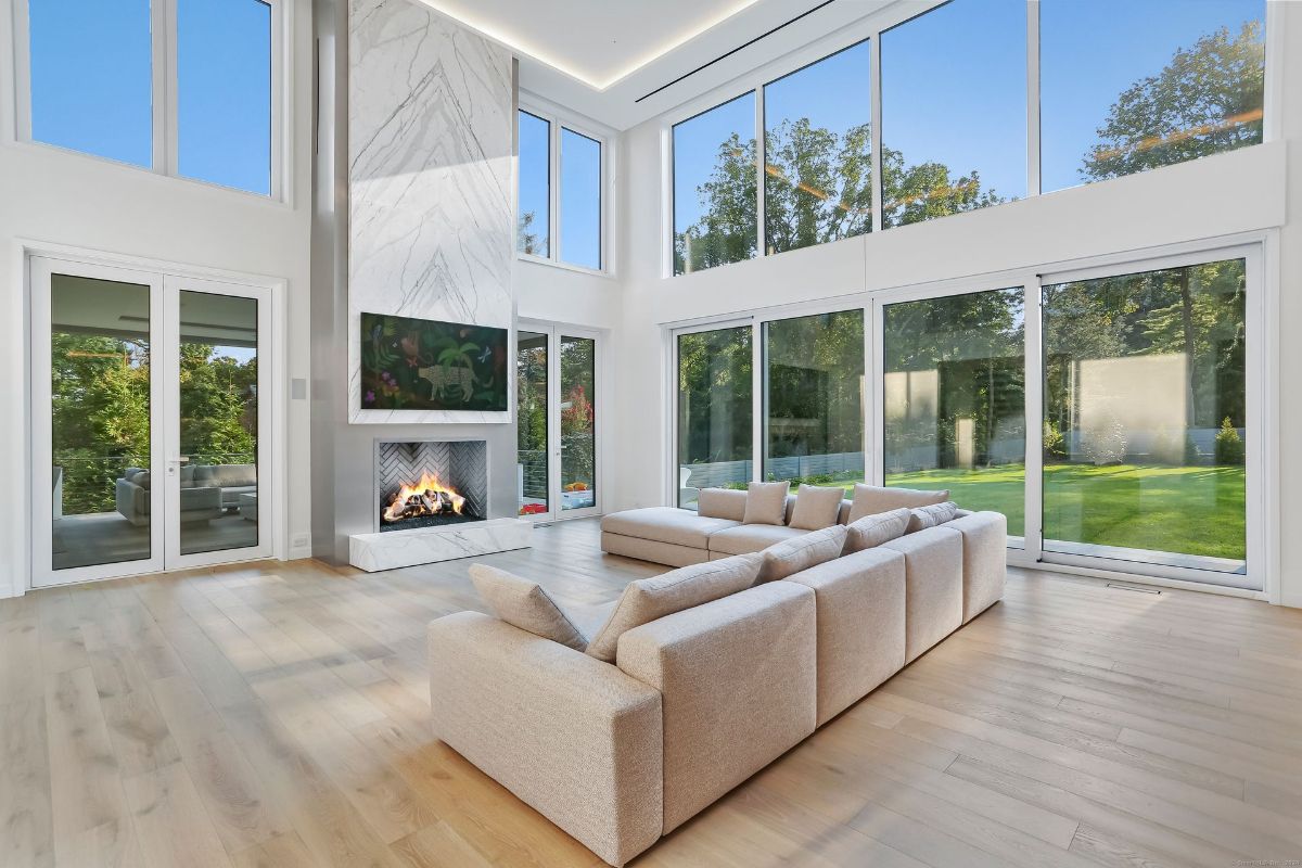 Floor-to-ceiling windows flood the living space with natural light, creating a seamless indoor-outdoor connection.