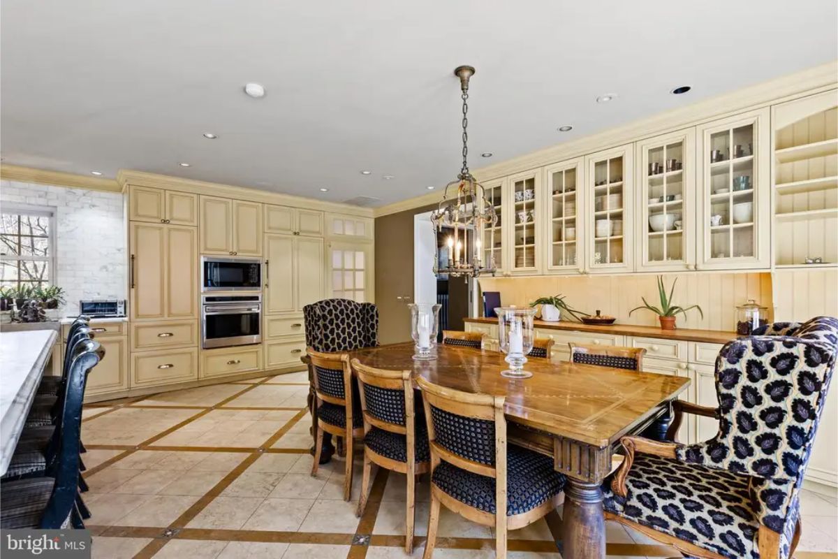 Custom cabinetry with glass display fronts, integrated appliances, and a tiled backsplash for a cohesive design.