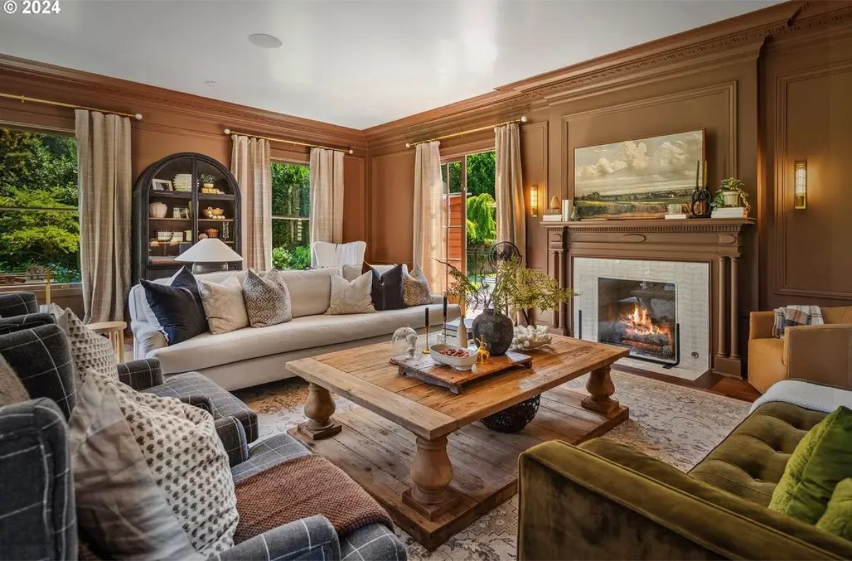 Living room has a cozy fireplace with a detailed mantle and a painting above it.