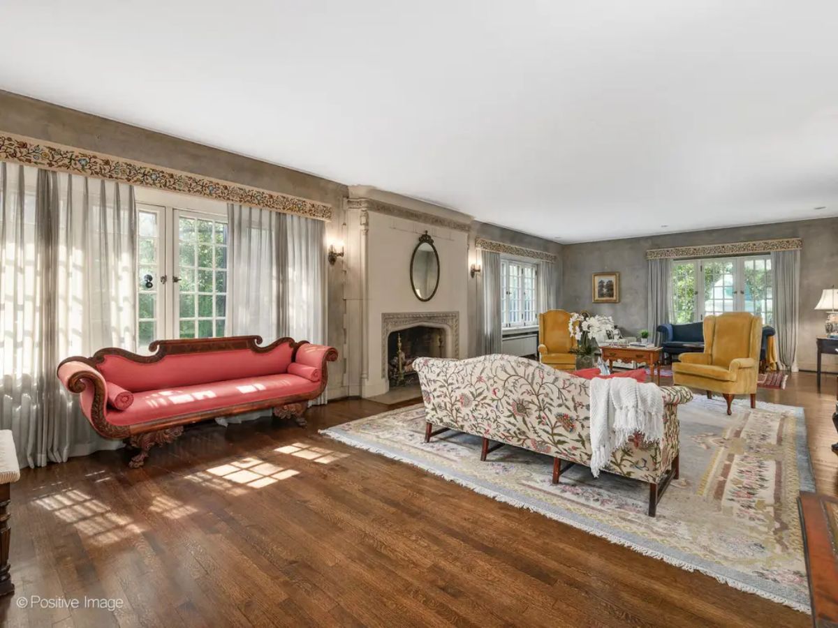 Bright living room features large windows with sheer drapes that fill the space with natural light.