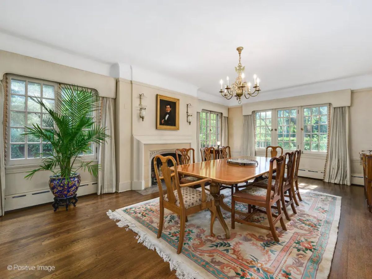 Large wooden dining table surrounded by classic chairs is the centerpiece of the room.