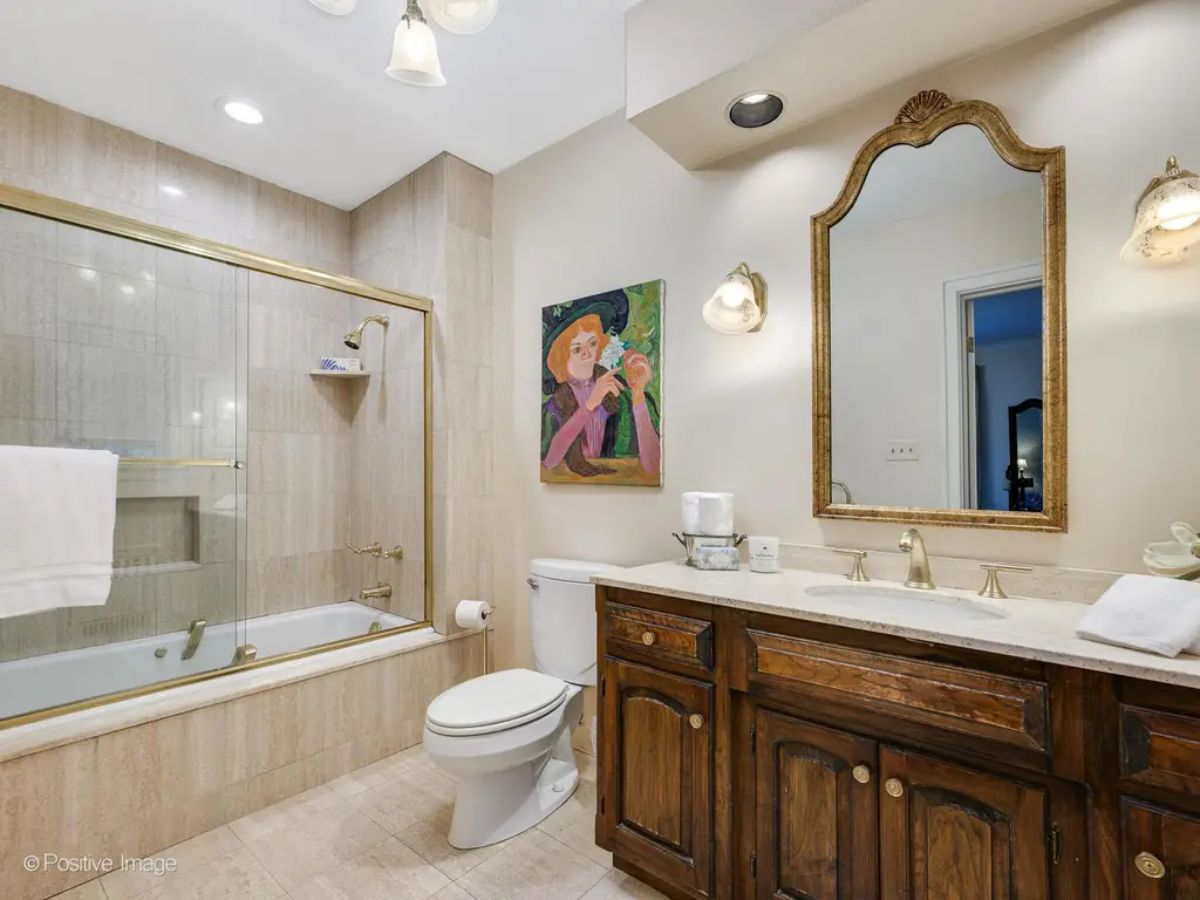 A wooden double-sink vanity with a stone countertop adds a rustic charm to the bathroom.