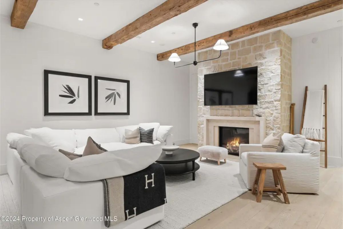 Exposed wood beams and a natural stone fireplace.