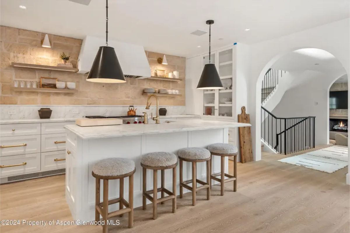 Harmonious blend of contemporary and rustic elements, featuring white marble countertops and a striking stone backsplash.