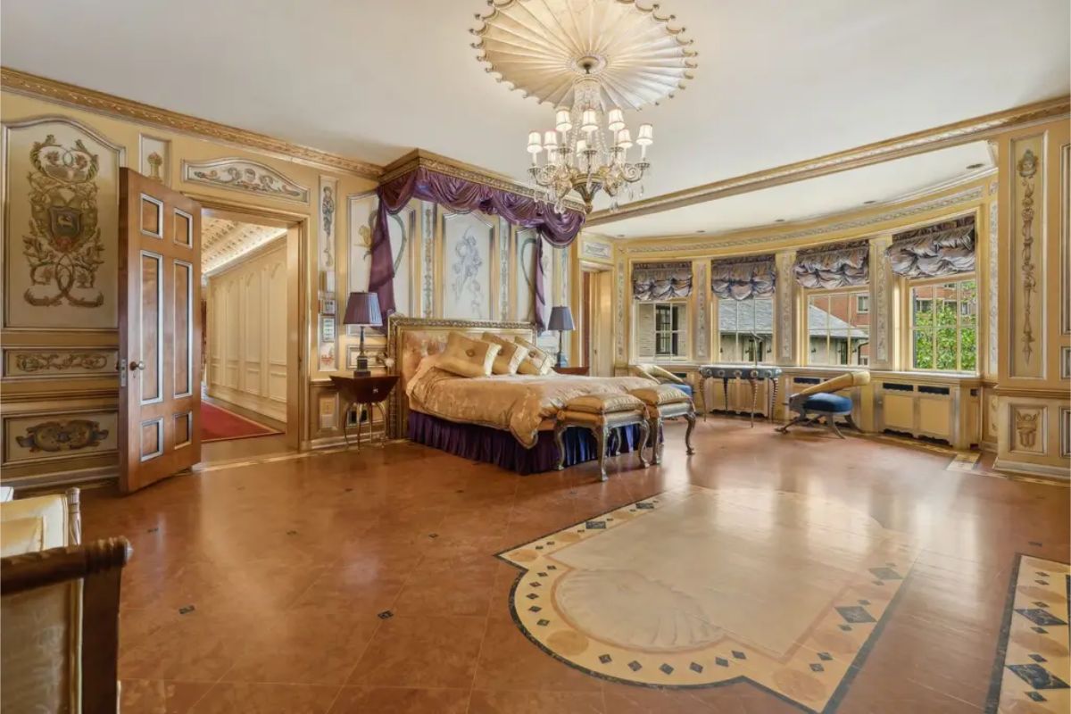 Bedroom with custom-painted walls featuring intricate patterns and heraldic motifs.