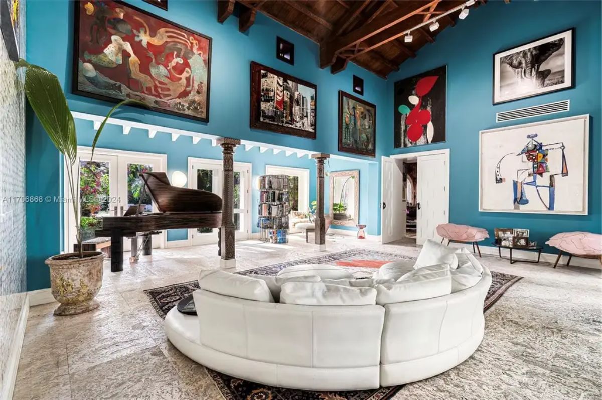 A bold blue walls adorned with large, colorful artworks and photographs.