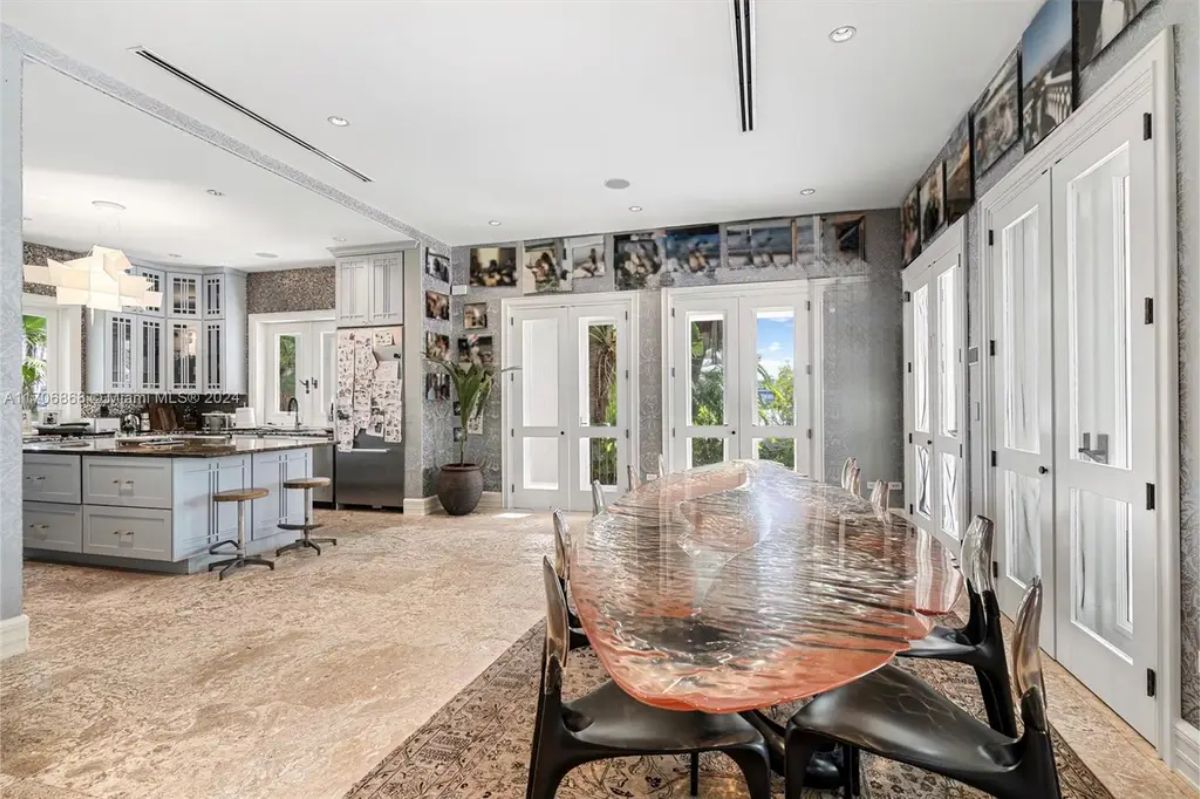 Open dining space featuring a long, sculptural dining table paired with modern transparent chairs.