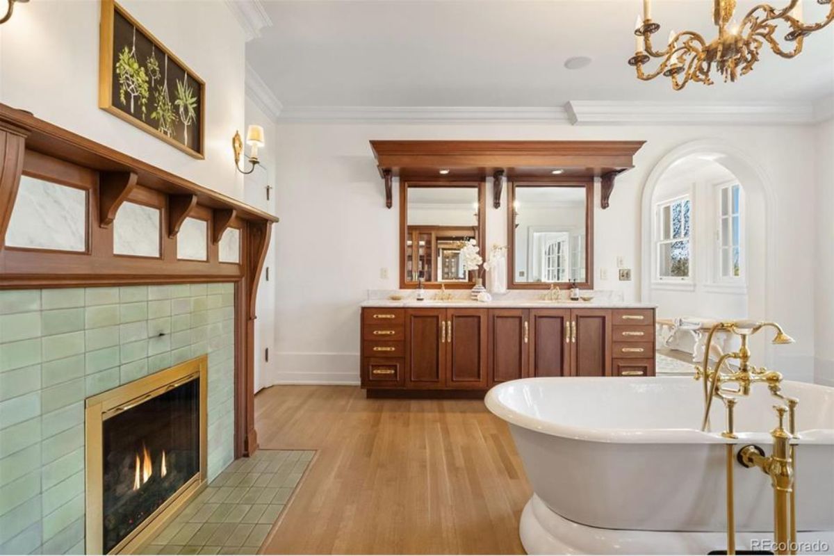 Dual-sink vanity featuring rich wood cabinetry and brass hardware.