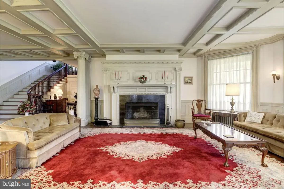 Spacious living room designed with a coffered ceiling and classic architectural details.