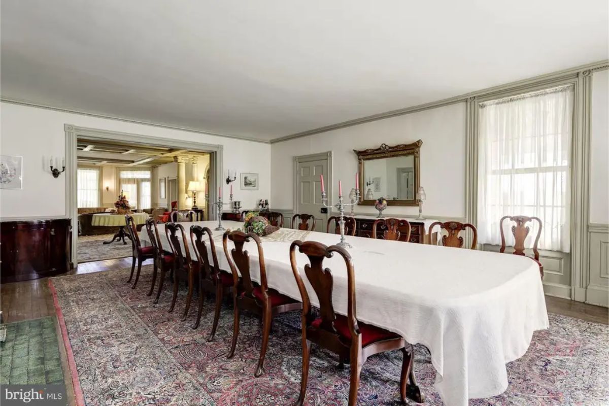 Expansive dining room showcasing an elegant, elongated table surrounded by traditional carved chairs.