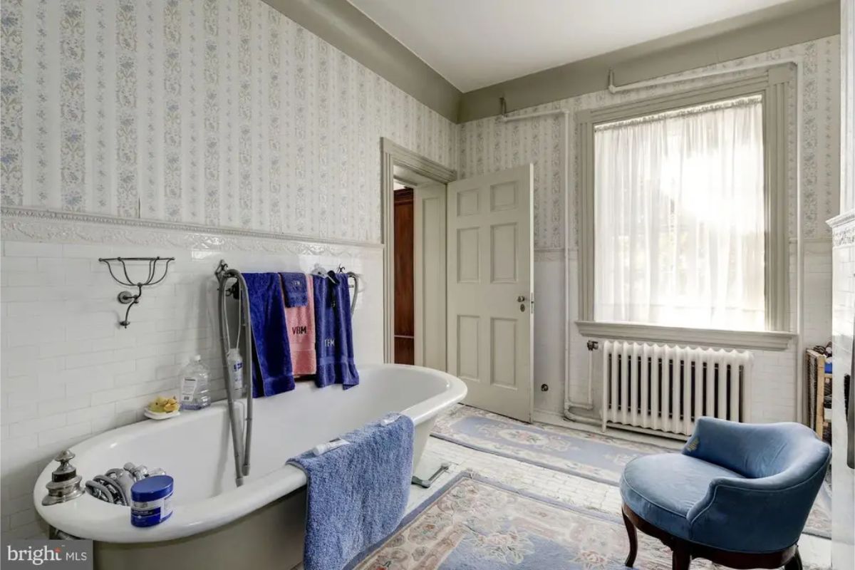 Bathroom with a vintage clawfoot tub and tiled walls.