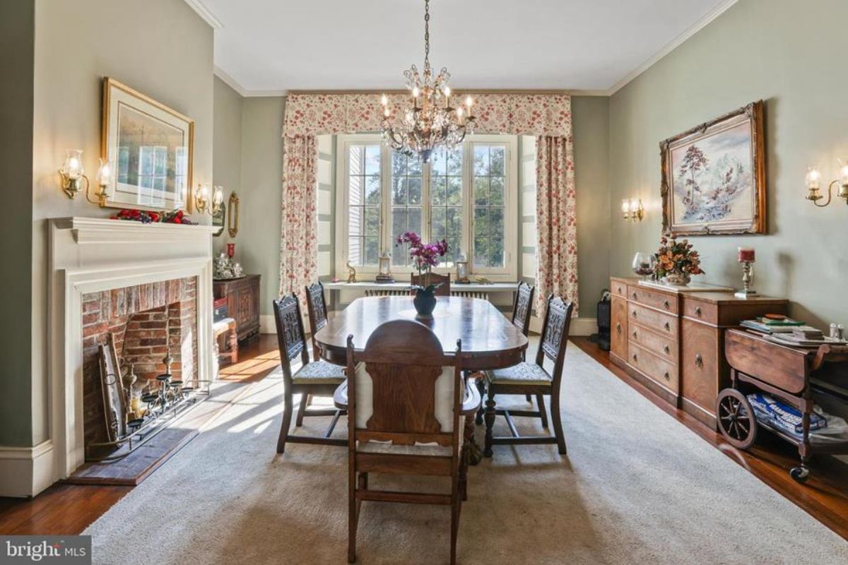 Formal dining room with a brick fireplace and a white mantel as the centerpiece.