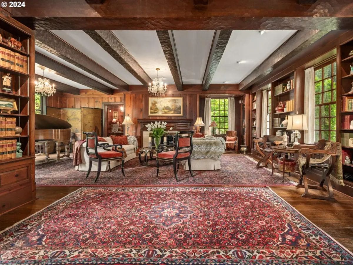 Living room showcases wood-paneled walls and exposed ceiling beams for a traditional feel.