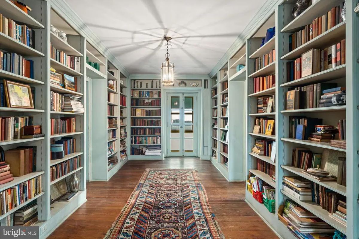 Hallway is lined with built-in bookshelves filled with an extensive collection of books and artifacts.