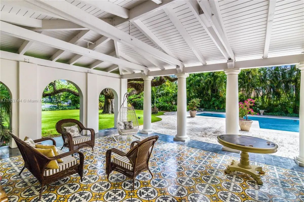 Covered patio with vaulted white ceilings, arched openings, and classic columns framing the space.