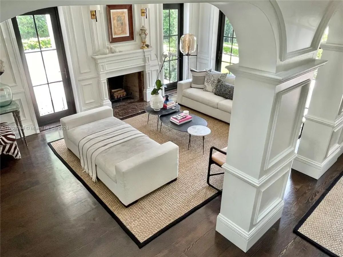 Bright living room with tall windows and French doors allowing natural light to fill the space.