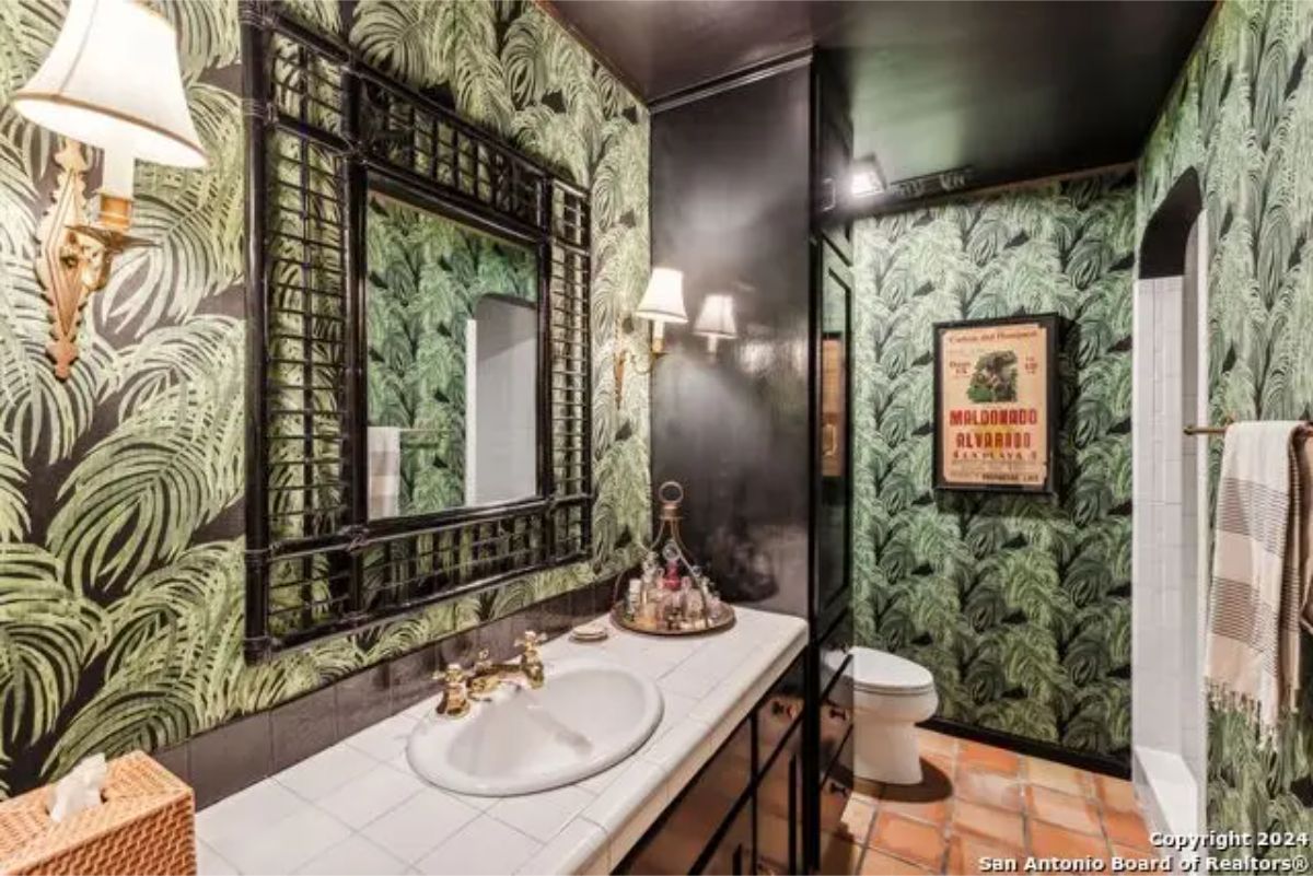 Bathroom with bold palm leaf wallpaper creating a vibrant atmosphere.