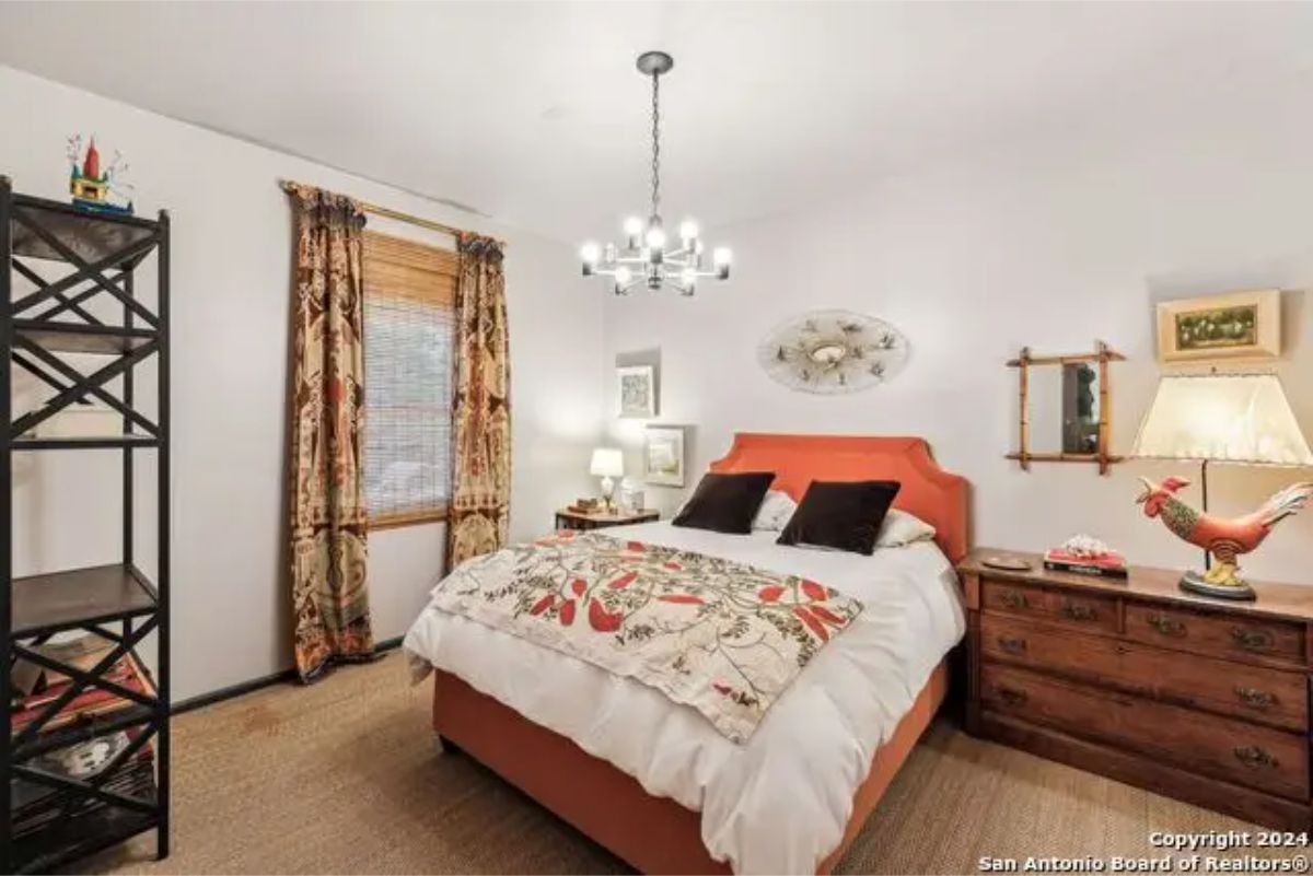 A vibrant orange headboard and patterned bedding creating a focal point.