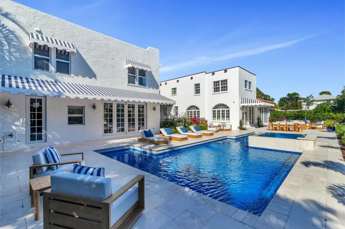 Outdoor area featuring a sparkling pool with an attached spa, surrounded by a tiled deck.