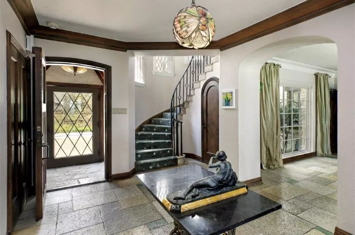 A diamond-paned glass door and large window provide natural light and charm to the entryway.