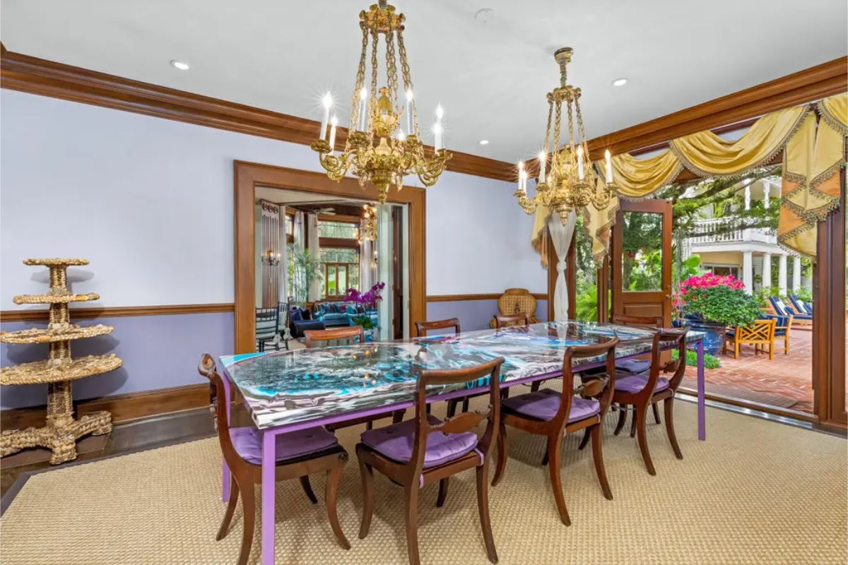 Dining room featuring dual ornate gold chandeliers and wooden accents throughout.