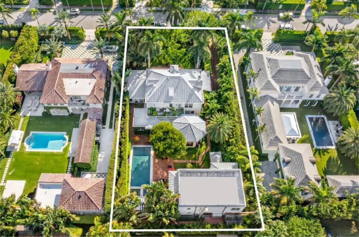 Bird's-eye view showcasing a meticulously maintained luxury property bordered by lush greenery and privacy hedges.