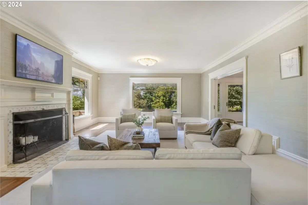 Living room with a centered black fireplace framed by white tile and molding.