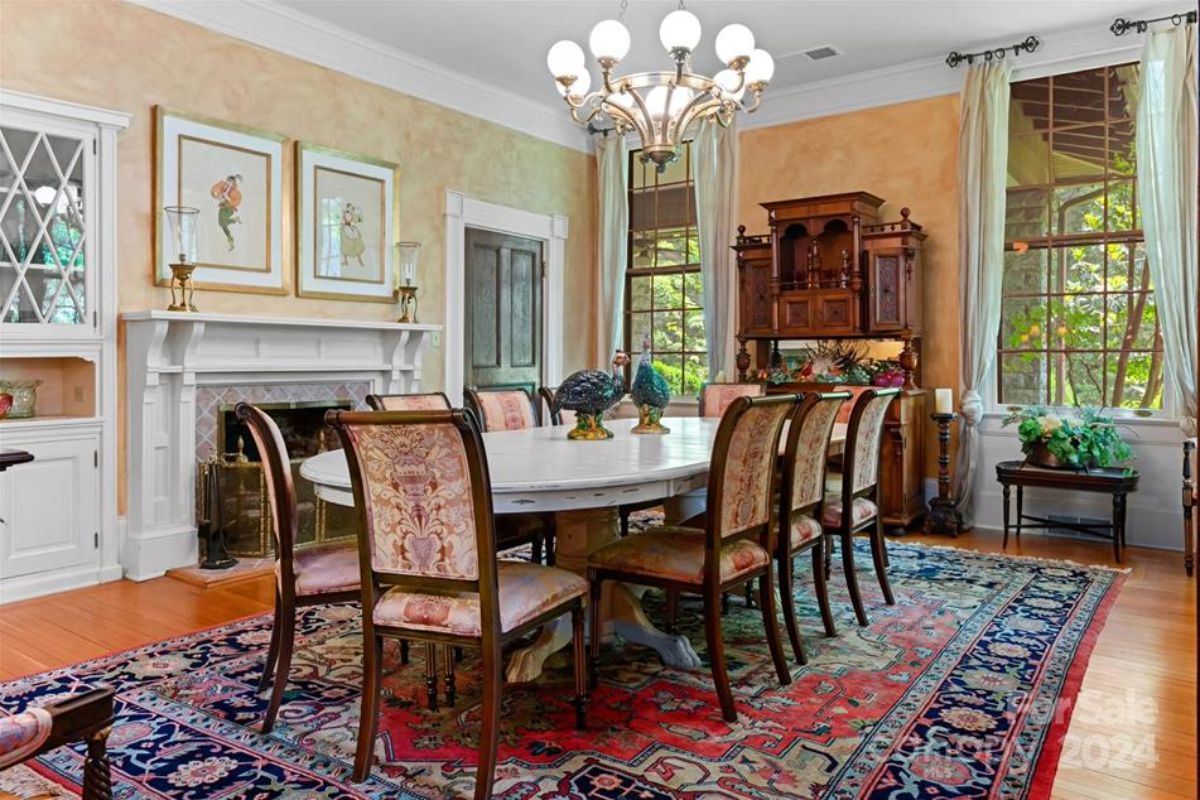 A formal dining room featuring a white oval table surrounded by patterned chairs.